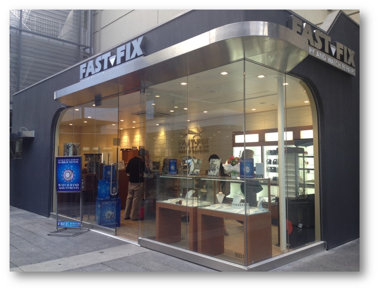 Picture of Fast-Fix store front in Century City Mall, CA. Glass walls that let people see the inside with the jewelry and watches on display.