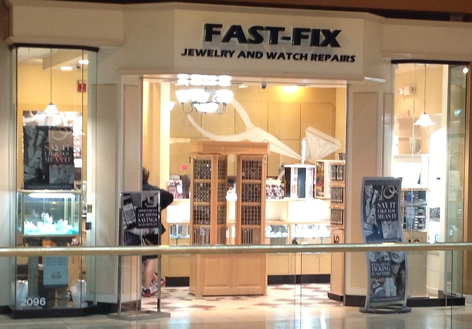 Storefront picture of Fast-Fix Jewelry and Watch Repairs store in Scottsdale, AZ. Front glass with 2 columns forming the entrance and the brand name on the top